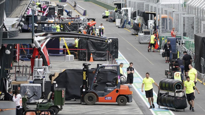 Workers pack up in pit lane after the cancellation of the Australian Formula One Grand Prix