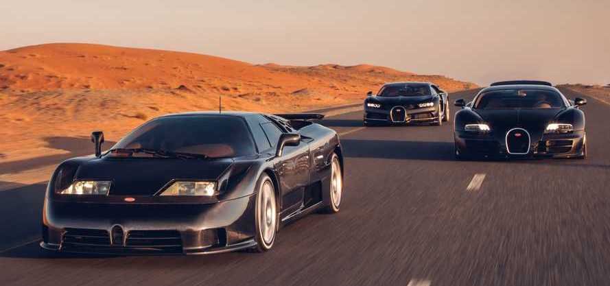 Bugatti’s three modern supercars – from the 1990s, 2000s, and 2010s – smile for the camera.
