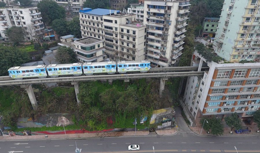 Crowded city builds a train track running through an apartment block
